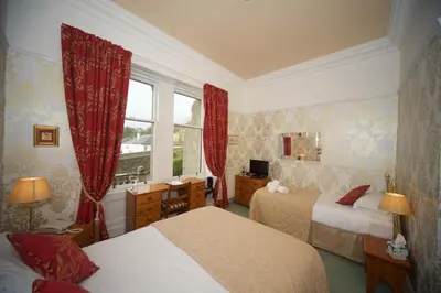 a hotel room with two beds and a window at Craigard House Hotel in Campbeltown