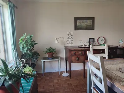 a dining room with a table and a desk with plants at Tobar nan Iasgair Lismore in Achnacroish