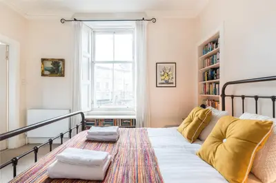 a bedroom with a bed and a book shelf at Spacious & Unique city central 1 bed with WiFi in Edinburgh