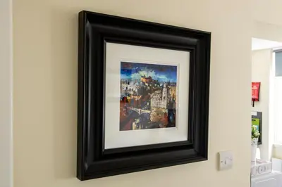 a framed painting of a city on a wall at Stunning Studio Apartment Castle View in Edinburgh