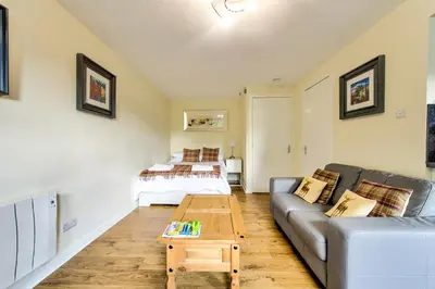 a living room with a couch and a table at Stunning Studio Apartment Castle View in Edinburgh