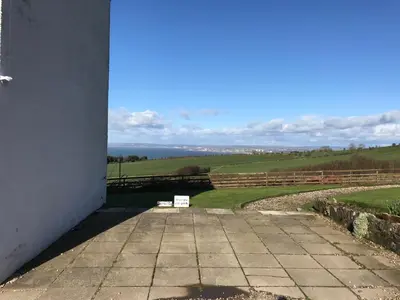 a view from the porch of a building with a view of the ocean at Carrick Hills Cosy Croft STL SA-00137-F in Dunure