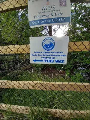 a sign on a fence that readsnext to the goop at Nevis Pod, West Highland Way Holidays in Kinlochleven