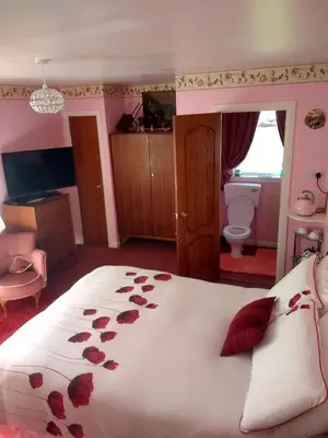 a bedroom with a large bed with roses on it at Lower Balwill in Buchlyvie