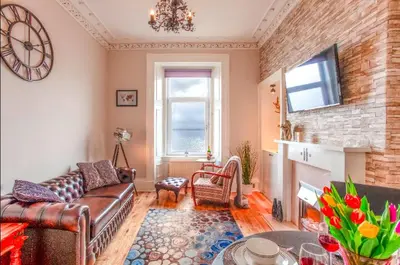 a living room with a couch and a fireplace at Clyde View Apartment in Helensburgh