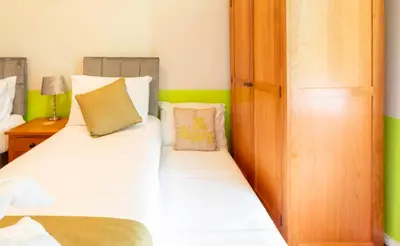 a bedroom with two beds with green and white at Clyde View Apartment in Helensburgh