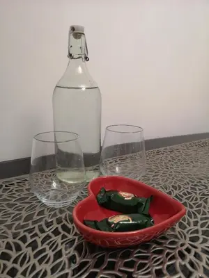 two wine glasses and a red bowl with a bottle at Sleep Well Apartment in Glasgow