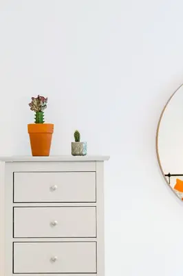 a white dresser with a mirror and plants on it at The Plywood Flat, Modern Style In A Traditional Tenement in Edinburgh