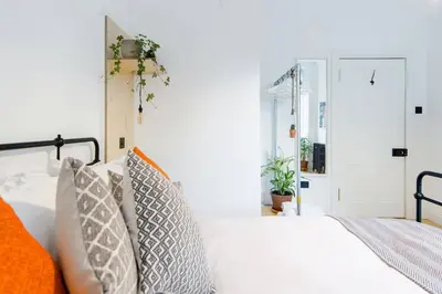 a bedroom with a white bed with pillows at The Plywood Flat, Modern Style In A Traditional Tenement in Edinburgh