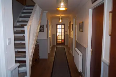a hallway of a home with stairs and a light fixture at Highland Croft B&B in Onich