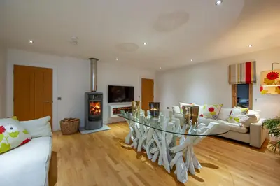 a living room with a glass table and a fireplace at Ardtorna in Benderloch