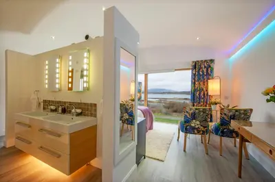a bathroom with a sink and a desk and a dining room at Ardtorna in Benderloch