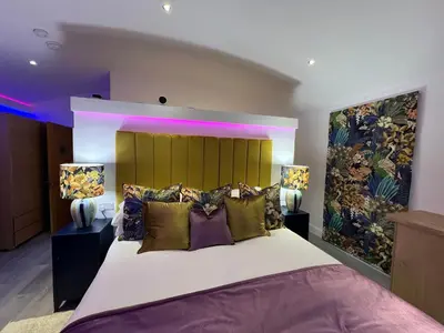 a bedroom with a large bed with colorful pillows at Ardtorna in Benderloch