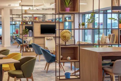 an office with chairs and tables and a tv at Hampton By Hilton Edinburgh Airport in Ingliston