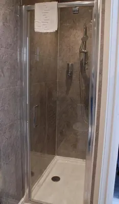a shower with a glass door in a bathroom at Miller House Courtyard in Ayr