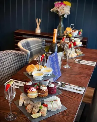 a table with a bunch of desserts and wine bottles at The Ranald Hotel in Oban