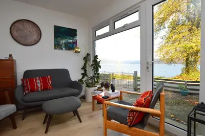 a living room with a view of the water at Gate Cottage in Tighnabruaich