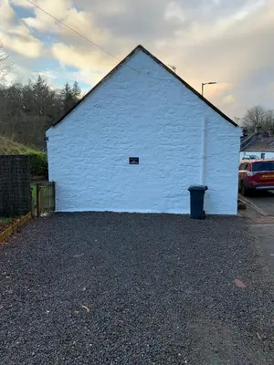 a white building with a small window on the side of it at Boggle Dyke Cottage in Thornhill