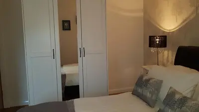 a bedroom with a bed and a closet and a lamp at Largs stay With Private parking in Largs