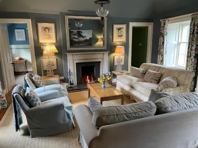 a living room with two couches and a fireplace at Neidpath Castle Cottage in Peebles