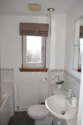 a white bathroom with a toilet and a sink at Kelpies Serviced Apartments-McKay in Falkirk