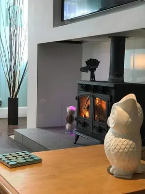 a living room with a fireplace and a stove at Vollie House with Hot Tub, Sauna & Log Burner in Penpont
