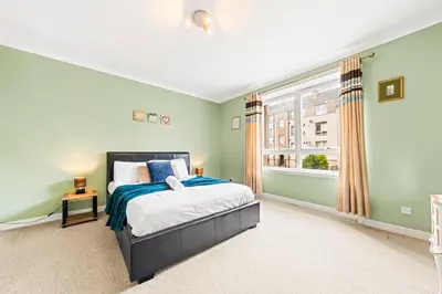 a bedroom with a bed and a window at Three Bed Holiday Home in Glasgow in Glasgow