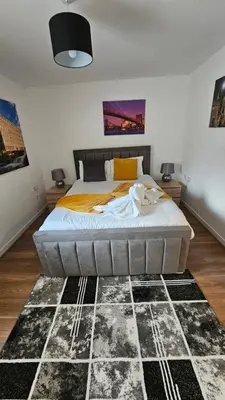 a bedroom with a large bed in a room at Silverburn new house with free parking and nice garden in Glasgow