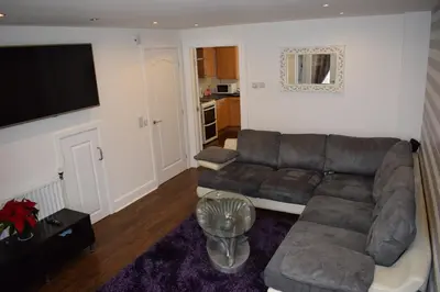 a living room with a couch and a flat screen tv at Silverburn new house with free parking and nice garden in Glasgow