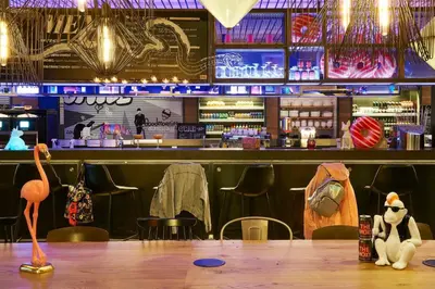 a bar with a table with a stuffed animal on it at Moxy Edinburgh Airport in Ingliston