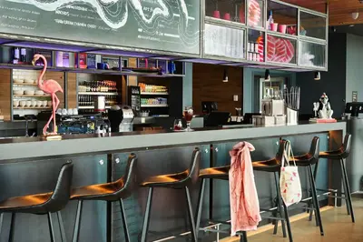 a bar with three flamingos sitting at a counter at Moxy Edinburgh Airport in Ingliston