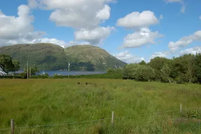 a field of grass with mountains in the background at Ben View in Taynuilt