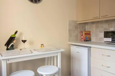 a kitchen with a counter with a wine glass and stool at South Groathill - Lovely 2 bed with Castle View in Edinburgh