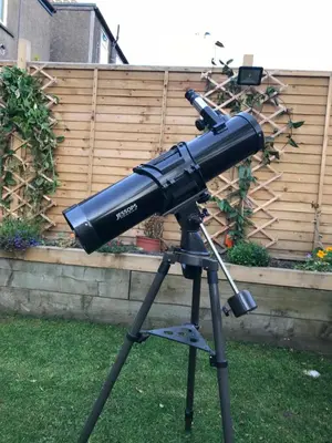a telescope on a tripod in a yard at A Wee Cottage In Dunfermline in Dunfermline