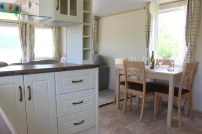 a kitchen and dining room with a table and chairs at Mountain View in Taynuilt