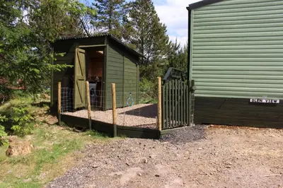 a green building with a gate in front of it at Glen View in Taynuilt