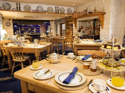 a room with tables and chairs with dishes on them at Champany Inn in Linlithgow