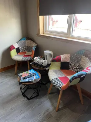 a room with two chairs and a table with cups on it at The Swan Inn in Stranraer