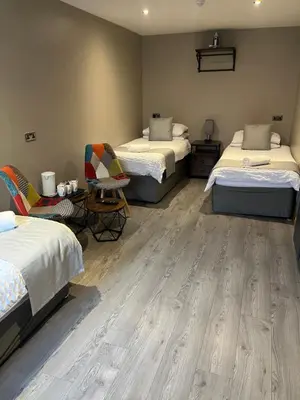 a room with two beds and a table and chairs at The Swan Inn in Stranraer