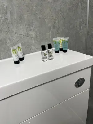 a white bathroom sink with four toothbrushes at The Swan Inn in Stranraer