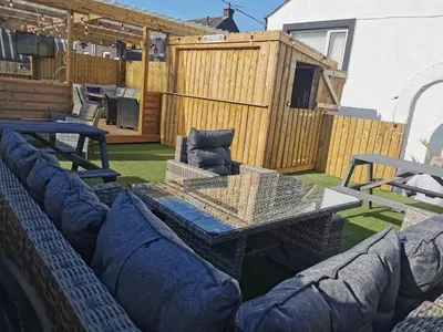 a patio with a table and couches on a yard at The Swan Inn in Stranraer
