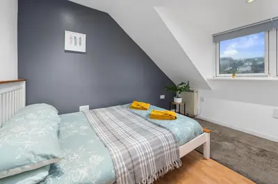 a bedroom with a bed and a window at Beautiful 2BR Apartment with McCaigs Tower views in Oban