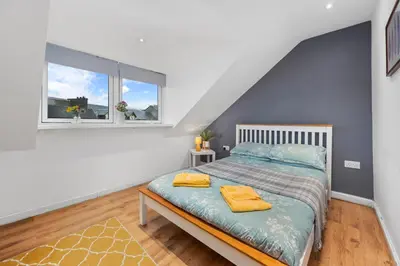 a bedroom with a bed and two windows at Beautiful 2BR Apartment with McCaigs Tower views in Oban