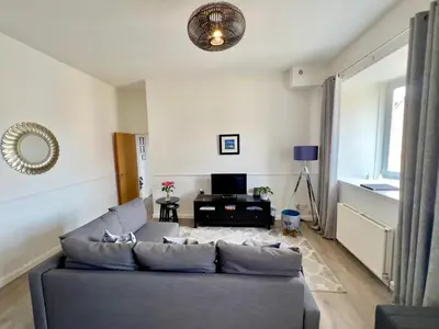 a living room with a couch and a television at Central Apartment Linlithgow in Linlithgow