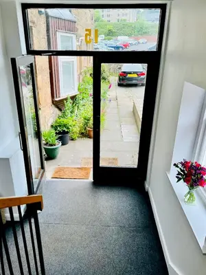 an open door with a view of a street with a car at Central Apartment Linlithgow in Linlithgow