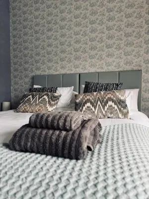 a bedroom with a large bed with a blanket and pillows at Lochwood Guest House in Lochgoilhead