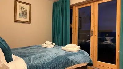 a room with two towels sitting on a bed at Glenisle Cottage in Lamlash