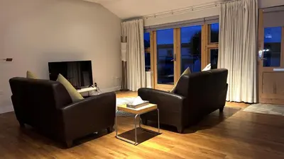a living room with two chairs and a television at Glenisle Cottage in Lamlash