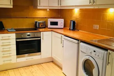 a kitchen with a washing machine and a microwave at JOIVY Warm & Welcoming Flat near Edinburgh Castle in Edinburgh
