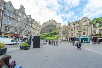 a group of people walking around a city street at JOIVY Warm & Welcoming Flat near Edinburgh Castle in Edinburgh